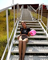 Pig-tailed Chick In Grey Pantyhose Is Playing Hot Toys With Herself Soccer Ball Outdoors