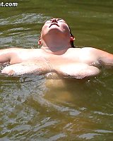 Older BBW with big saggy tits psoes nude outdoors by the lake
